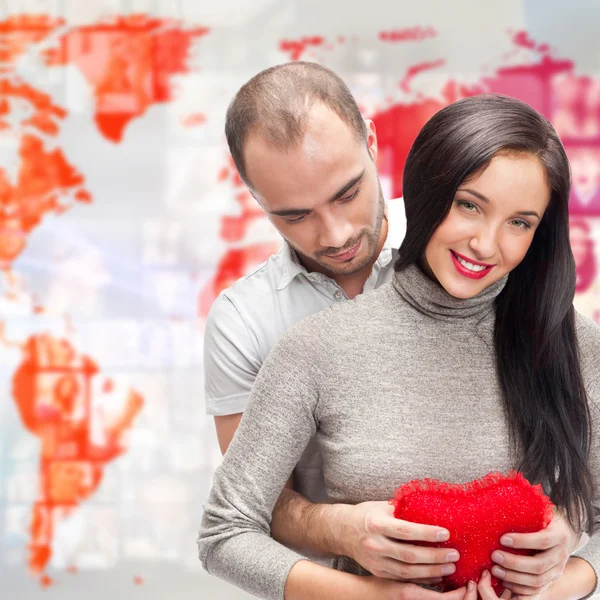 Portrait of young couple embracing and holding red heart. Standi — Stock Photo, Image
