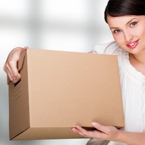 Closeup portrait of pretty adult woman holding a box at office b — Stock Photo, Image