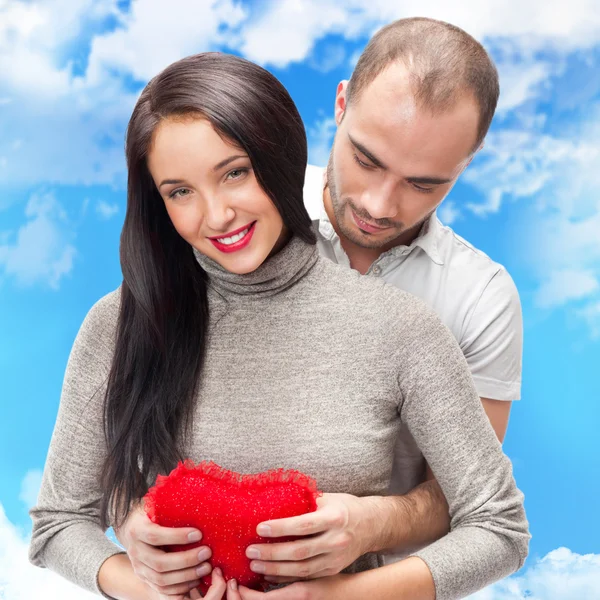 Happy young adult couple with red heart on romantic background w — Stock Photo, Image