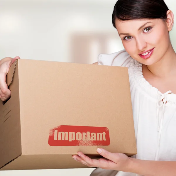 A woman holding a box inside office building or home interior. P — Stock Photo, Image