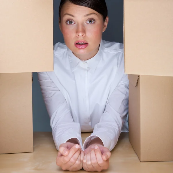 Portrait of young woman surrounded by lots of boxes. Lots of wor — Stock Photo, Image