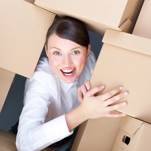 Retrato de una joven rodeada de muchas cajas. Mucha varita. — Foto de Stock