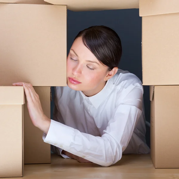Portrait of young woman surrounded by lots of boxes. Lots of wor — Stock Photo, Image