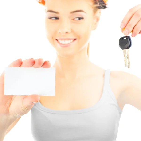 Happy woman wearing protective helmet holding new key and blank — Stock Photo, Image