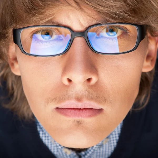 Zufriedener junger Mann mit Brille blickt in Kamera wie auf Lapto — Stockfoto