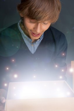 Portrait of young man opening gift box. He is happy. Magical shi clipart