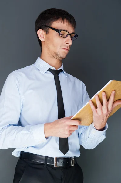 Primer plano de un joven hombre de negocios sonriente de pie con confianza aga — Foto de Stock