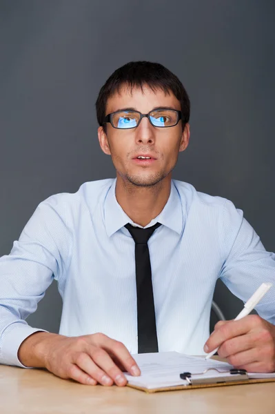 Портрет взрослого бизнесмена, сидящего в офисе и подписывающего — стоковое фото
