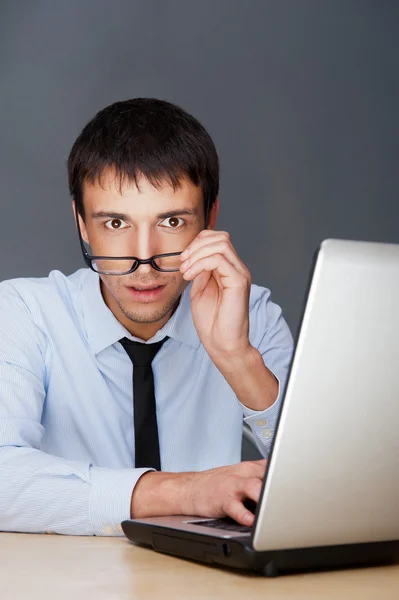 Portret van een volwassen bedrijf man zit door zijn laptop in de o — Stockfoto