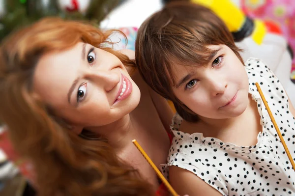 Mother and her daughter sitting together near christmas tree — Stock Photo, Image
