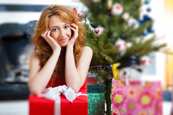Mujer de Navidad cerca de un árbol de Navidad sosteniendo gran caja de regalo mientras — Foto de Stock