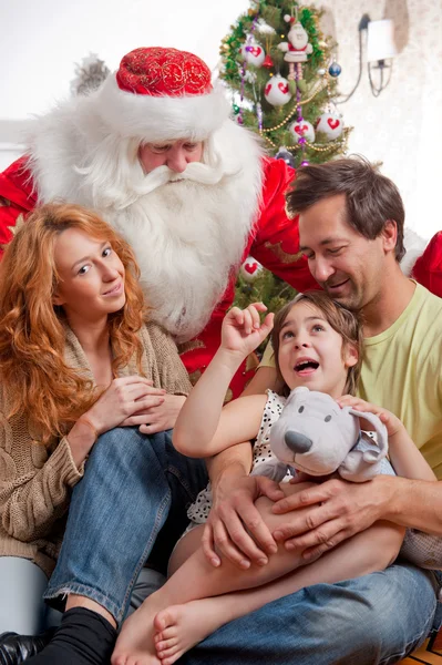 Happy family embracing and sitting on the floor in front of Chri — Stockfoto