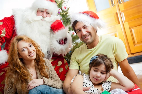 快乐家庭拥抱和坐在圣诞前面的地板上 — 图库照片