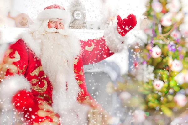 Weihnachtsmann sitzt am Weihnachtsbaum, am Kamin und schaut — Stockfoto