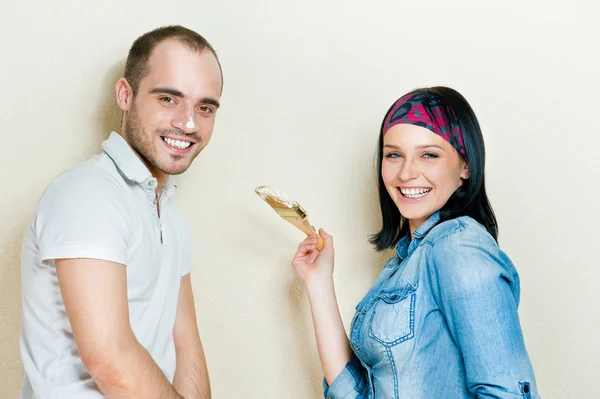 Feliz jovem casal pintando sua casa — Fotografia de Stock