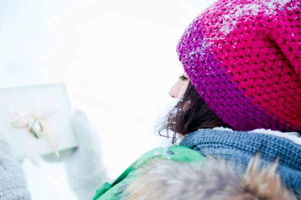 Unga dam beundra en närvarande ute på vintern — Stockfoto