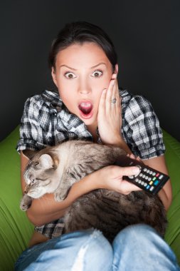 Young funny woman sitting in her beanbag and embracing her cat w clipart