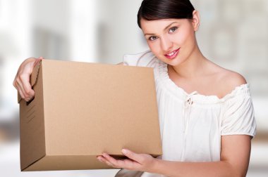 Young woman moving into a new home. Great copy space. clipart