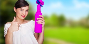 Portrait of young pretty woman holding bottle of prefect wine in clipart