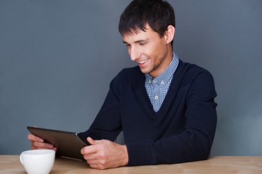 Closeup of a young smiling business man sitting at his office ag clipart