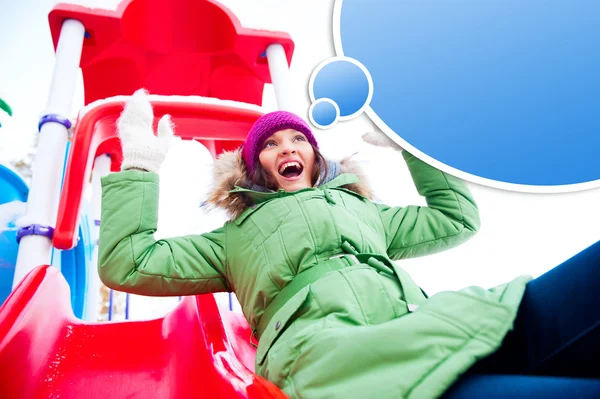 Portrait of young pretty playful woman riding down at playground — Stock Photo, Image