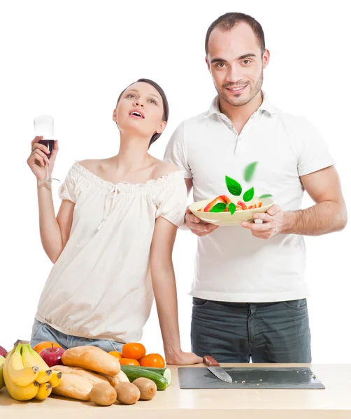 Jeune beau couple cuisinant une alimentation équilibrée sur un fond blanc — Photo