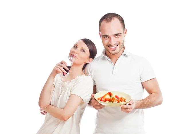 Junges hübsches Paar, das auf weißem Hintergrund eine ausgewogene Ernährung zubereitet — Stockfoto