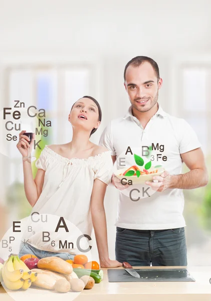 Playful young couple in their kitchen preparing healthy food and — Stock Photo, Image