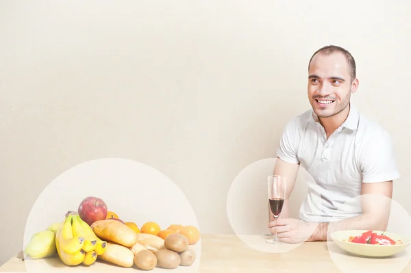 Porträtt av en ung man med ett glas vin medan matlagning. Co — Stockfoto