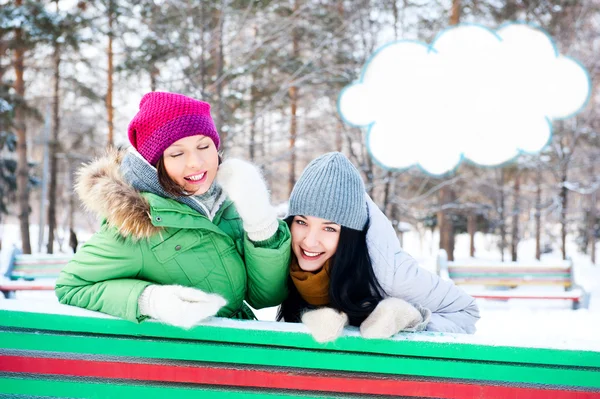 Two happy young girls having fun in winter park. Blank cloud bal — Stock Photo, Image