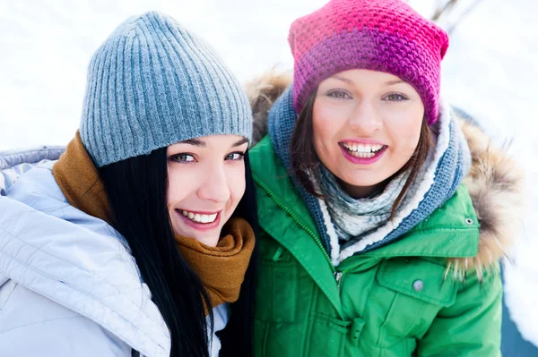 Två glada unga flickor att ha kul i vinter park — Stockfoto
