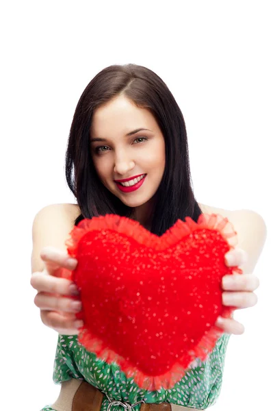 Cute young woman holds a heart symbol isolated on white background — Stock Photo, Image