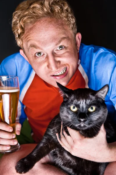 Konstnärliga porträtt av ung man och hans katt både tittar på kameran — Stockfoto