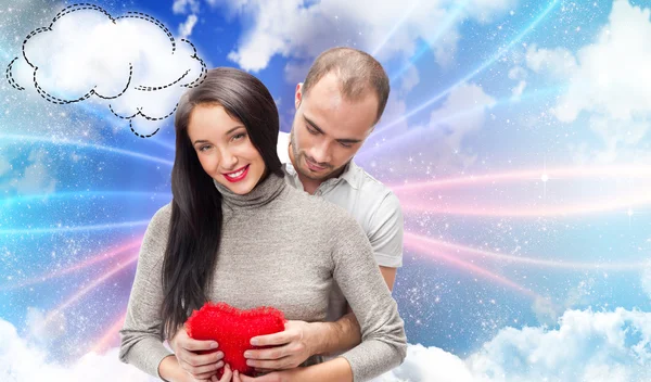 Šťastný mladý dospělý pár s červeným srdcem na romantické pozadí — Stock fotografie