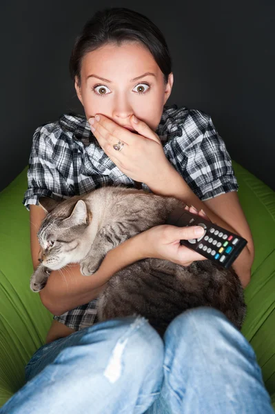 Mladá zábavný žena sedí v jejím beanbag a všeobjímající její kočka w — Stock fotografie
