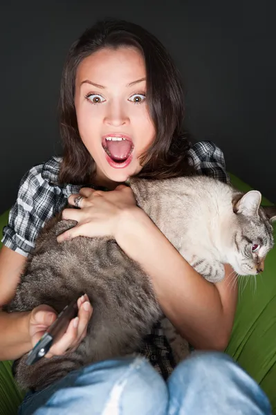 Молодая забавная женщина сидит в своем мешке и обнимает свою кошку — стоковое фото