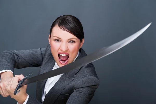 Mujer de negocios mostrando determinación mientras sostiene una espada — Foto de Stock