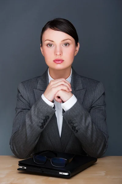 Porträt einer jungen hübschen Frau, die mit Brille in ihrem Büro sitzt — Stockfoto