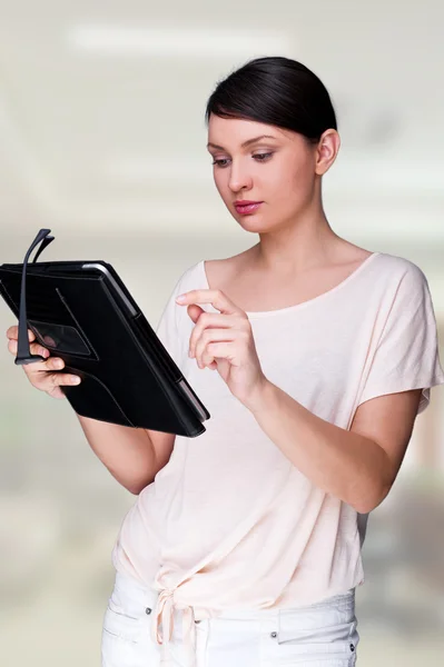 Retrato de una joven mujer bonita sosteniendo una tableta — Foto de Stock