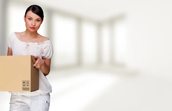 Uma mulher segurando uma caixa dentro do prédio de escritórios ou do interior da casa. P — Fotografia de Stock