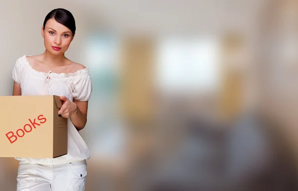 Smiling woman holding boxes and looking at the camera she is mov — Stock Photo, Image