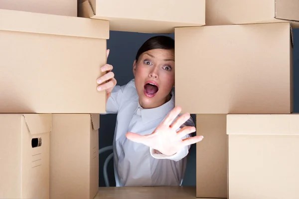 Ritratto di giovane donna circondata da molte scatole. Un sacco di wor — Foto Stock