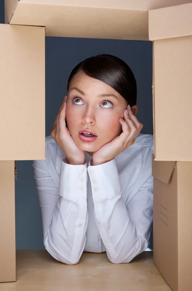 Retrato de jovem cercada por muitas caixas. Lotes de wor — Fotografia de Stock