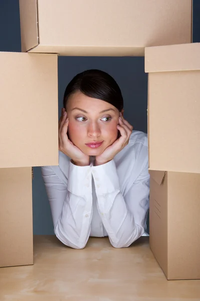 Portrait of young woman surrounded by lots of boxes. Lots of wor — Stock Photo, Image