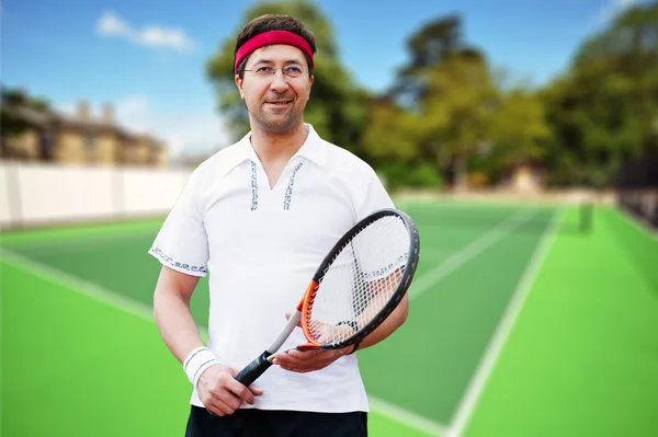 Mature business man playing tennis at his backyard of his house