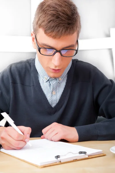 Střední školy - mladý muž student psát poznámky v učebně — Stock fotografie