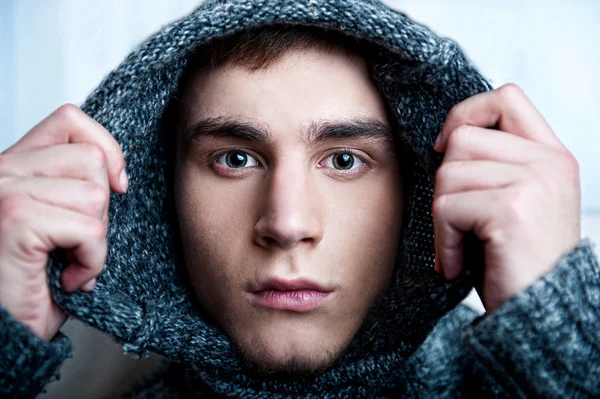 Portrait of young handsome man putting on warm pullover and look — Stock Photo, Image