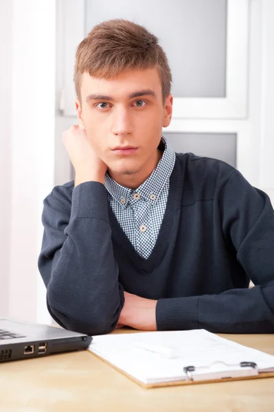 Mężczyzna młody student pracuje w jasny pokój, siedząc przy biurku, za pomocą — Zdjęcie stockowe
