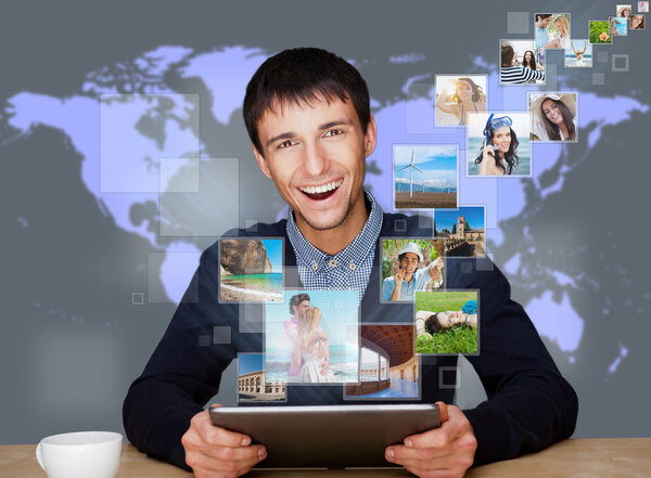 У технологического человека есть изображения, улетающие от его современного планшета С
