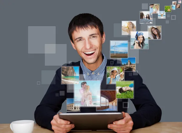 Retrato de jovem feliz homem compartilhando suas fotos e arquivos de vídeo em — Fotografia de Stock